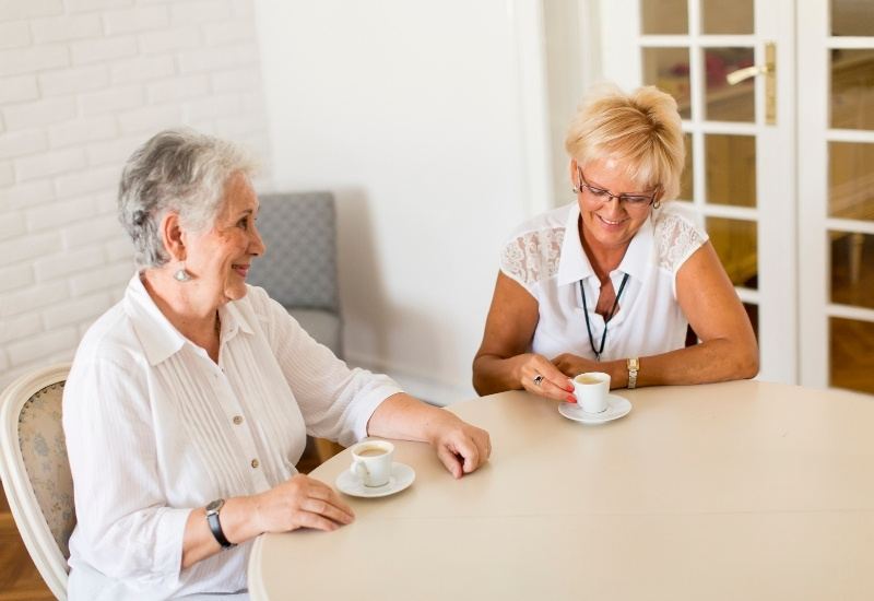 Two women talking over coffee at a table
