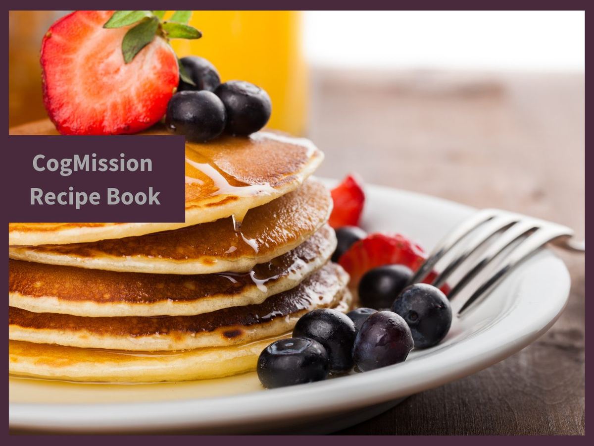 Stack of pancakes with syrup, blueberries and strawberries on a plate, labelled CogMission Recipe Book