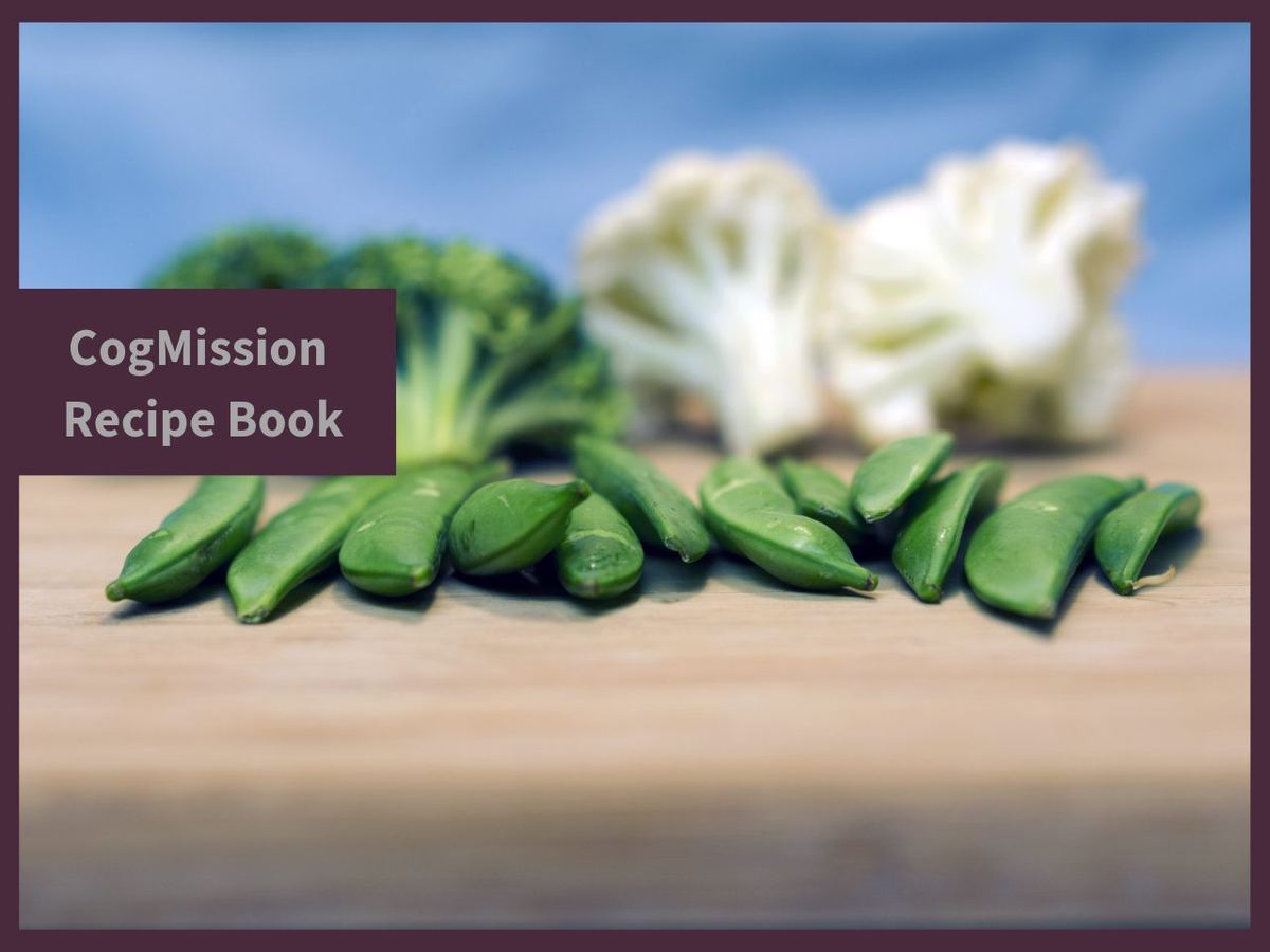 CogMission Recipe Book cover with fresh broccoli, cauliflower and sugar snap peas on a wooden board