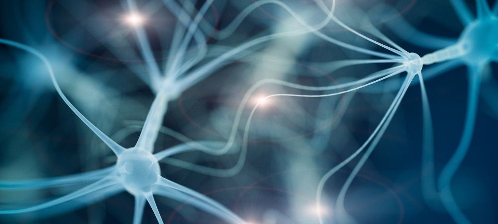 Glowing blue neurons with branching dendrites linked together, with points of light showing signals travelling between them